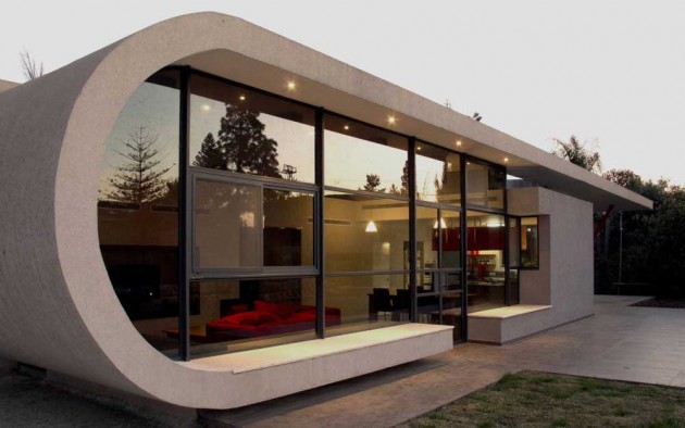 Casa com formato diferenciado, ovalado, com fachada de vidro como parede.