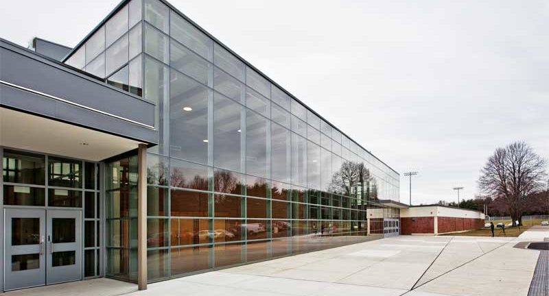 Prédio comercial horizontal de um andar com grande fachada de vidro.