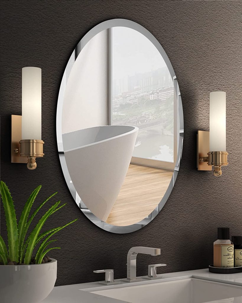 Espelho oval com bisotê em banheiro.