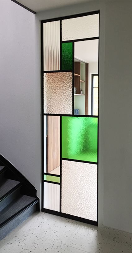Divisória de ambiente feita com diferentes tipos de vidro fantasia combinados.